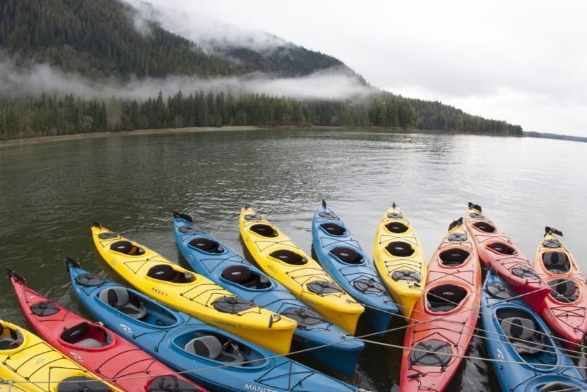 Assortment of empty colorful kayaks on a mountain lake