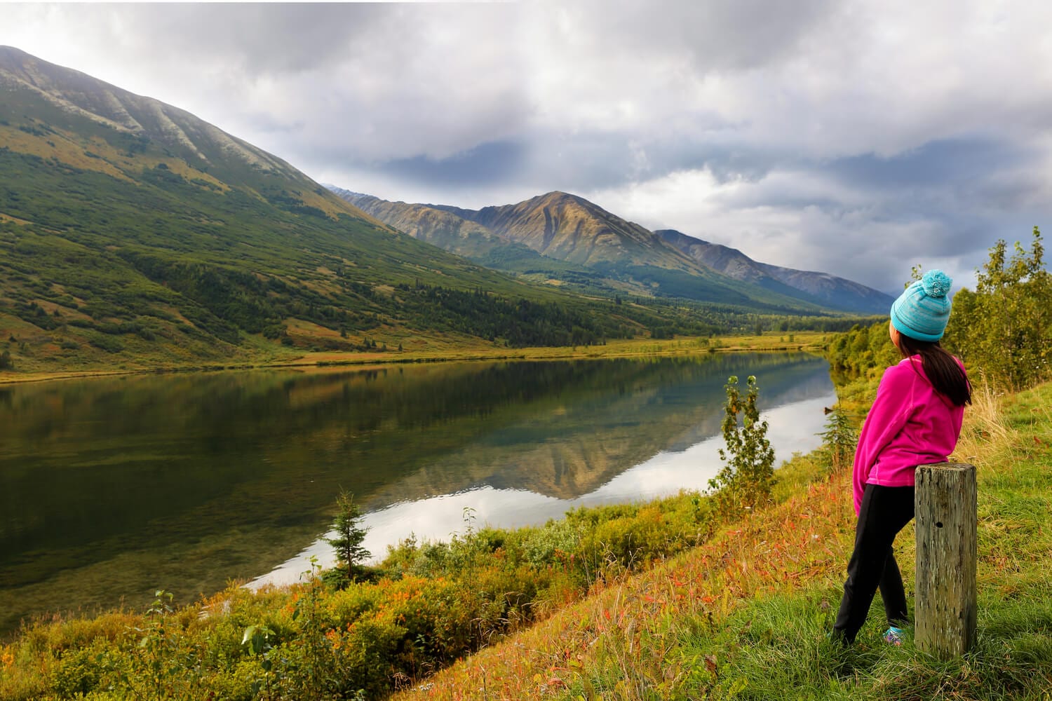 An eager traveler looks on at the Chugach National Forest while enjoying an Alaskan adventure.
