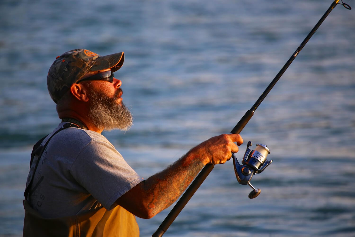 A seasoned fisherman examines his rig before casting on an Alaskan fishing trip.