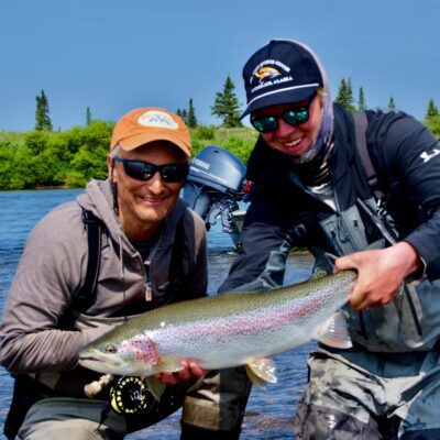 kenai river fishing guide holding a rainbow trout with client